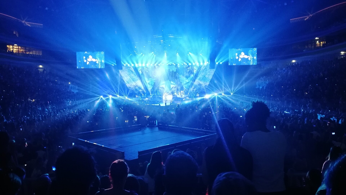blue concert lights spreading across a large arena audience