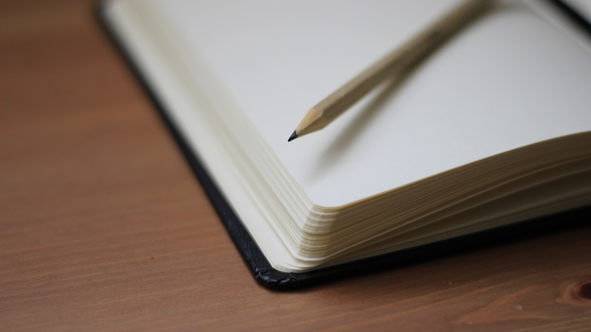 shallow focus photography of pencil on book